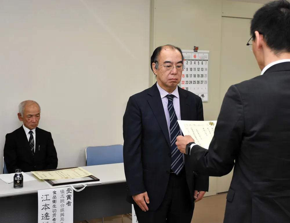 表彰状を受ける三印菊地水産の菊地均社長（中央）と江本達雄さん（左）