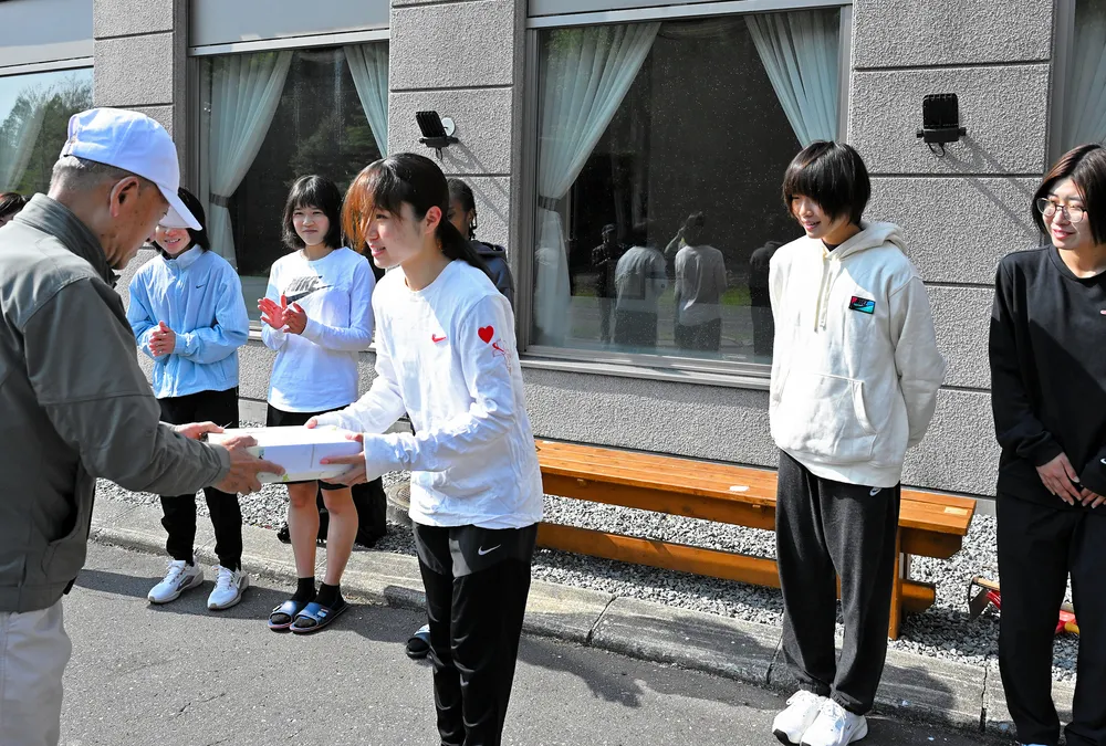 記念品を手渡す鈴木勉代表（左）