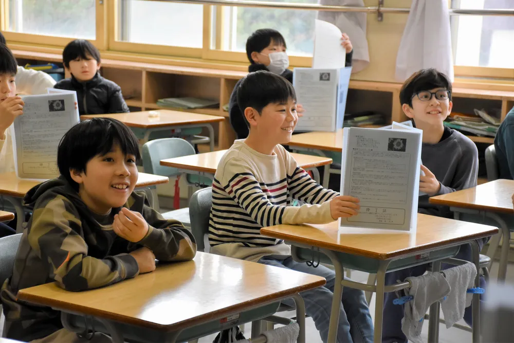 通知表を受け取り、新しい学年に向け楽しみにしていることなどを話す旭小の児童たち