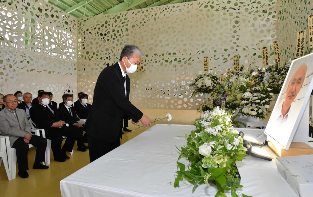 献花台に花を手向ける参加者