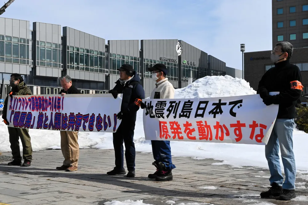 横断幕を掲げて脱原発を訴える参加者