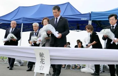 決壊現場での追悼式で献花する神達岳志市長（中央）ら=10日午後、茨城県常総市