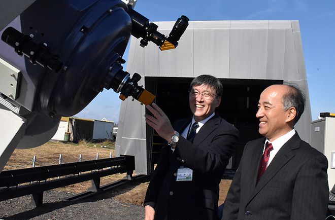設置された望遠鏡を前に喜びを語り合う山本修さん（左）と林美輝さん＝２日