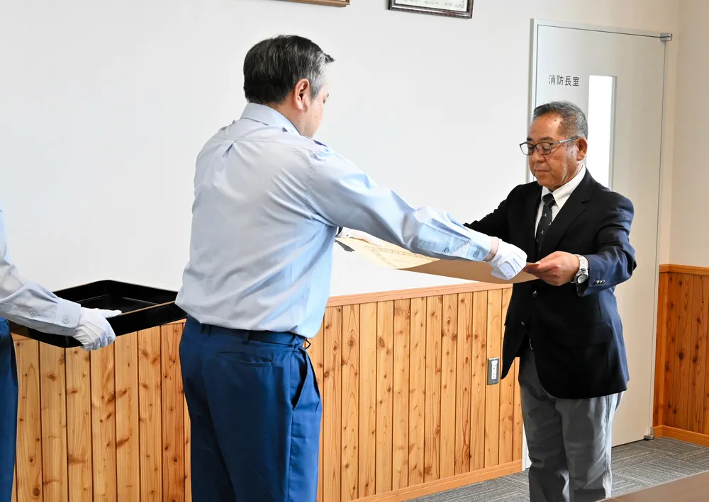 伝達式で勲記を受け取る木村富士夫さん（右）