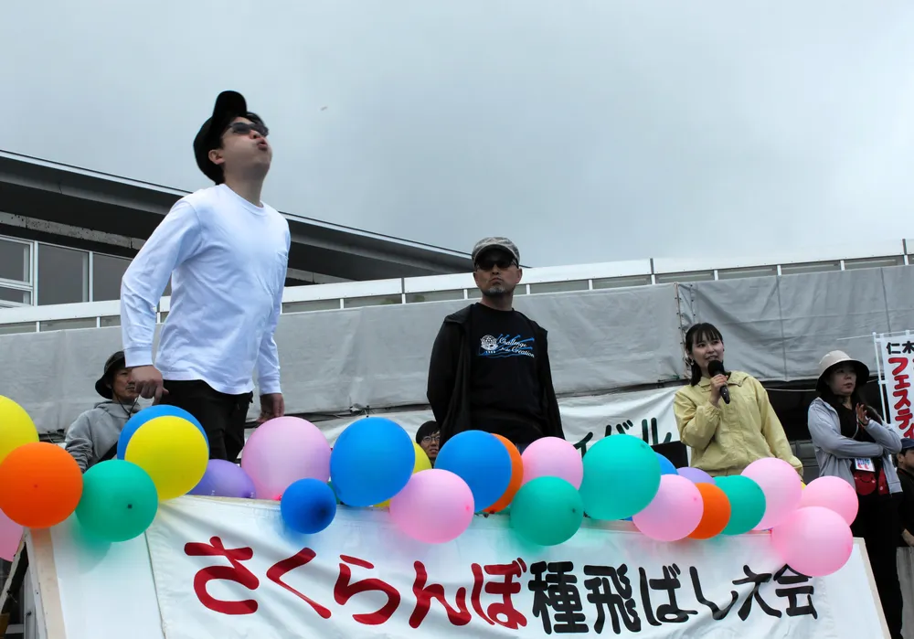 サクランボの種飛ばし大会で種の到達距離を競う参加者