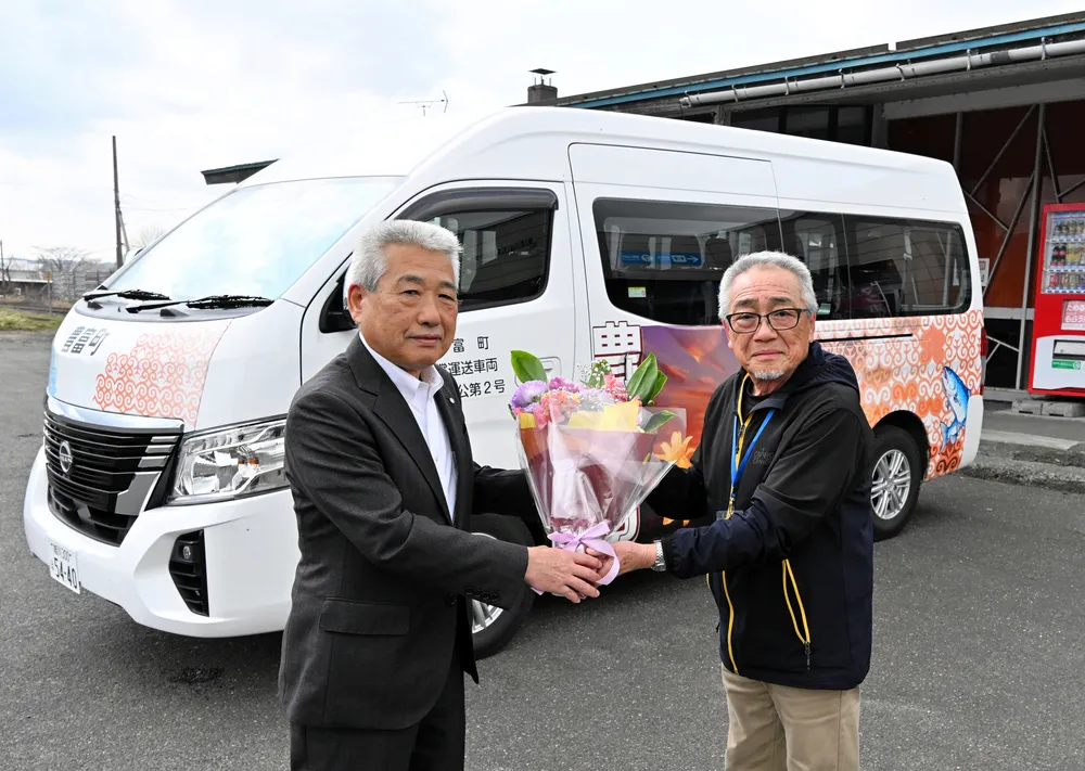 デマンドバス運行を前に、運転手の代表に花束を手渡す河田町長（左）
