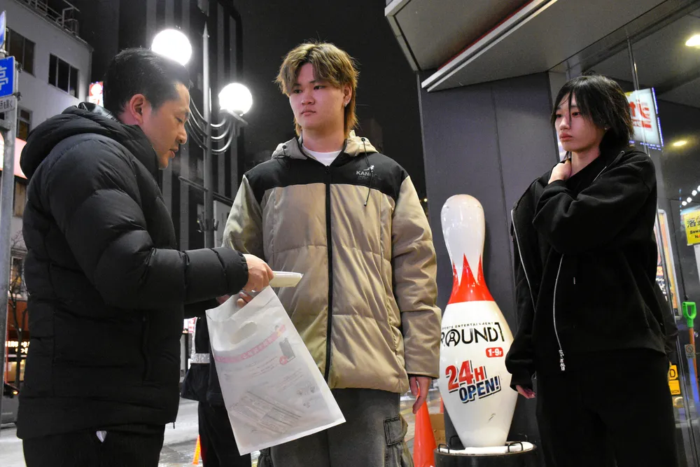 札幌・ススキノを訪れた若者に闇バイトや大麻の危険性を訴える札幌中央署の警察官（左)