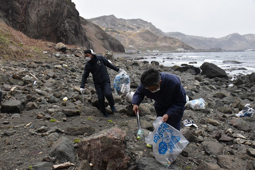 地蔵岩付近の海岸でプラスチックごみを拾う参加者ら 