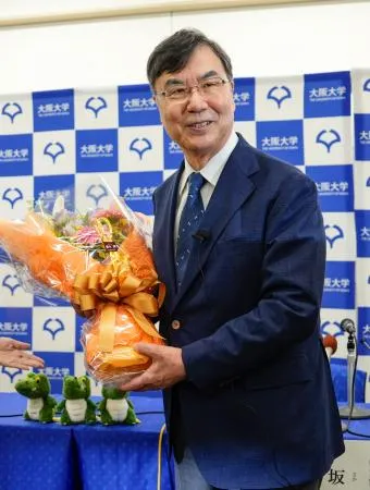 ノーベル生理学・医学賞の受賞が決まり、記者会見場で花束を手に笑顔を見せる大阪大の坂口志文特任教授=6日午後8時3分、大阪府吹田市