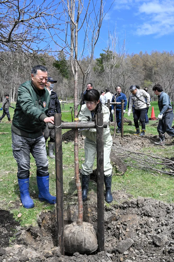 パークゴルフ場にサクラを植樹する参加者たち