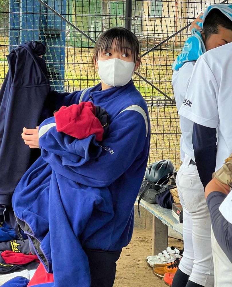 選手の上着を集める藤倉さん。「試合に負けても頑張っている選手の姿を見て支えたいと思った」＝３月５日、水戸市内