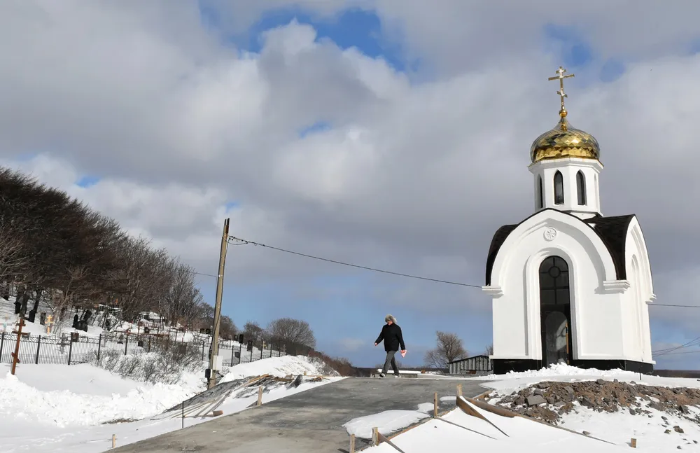 択捉島紗那に建てられたウクライナでの戦没者を追悼するロシア正教会の礼拝堂。左に見える墓地の一角には日本人の墓が残っている＝2月14日