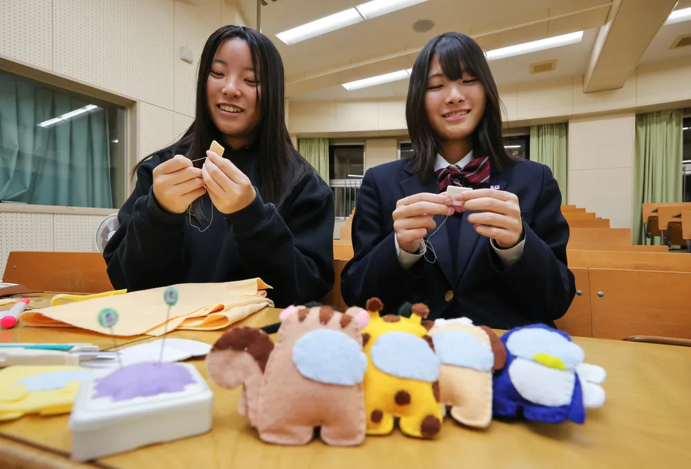 花園に挑む選手たちに贈るお守りを作る清水弥恵さん（右）と荒井結花さん（星野雄飛撮影）