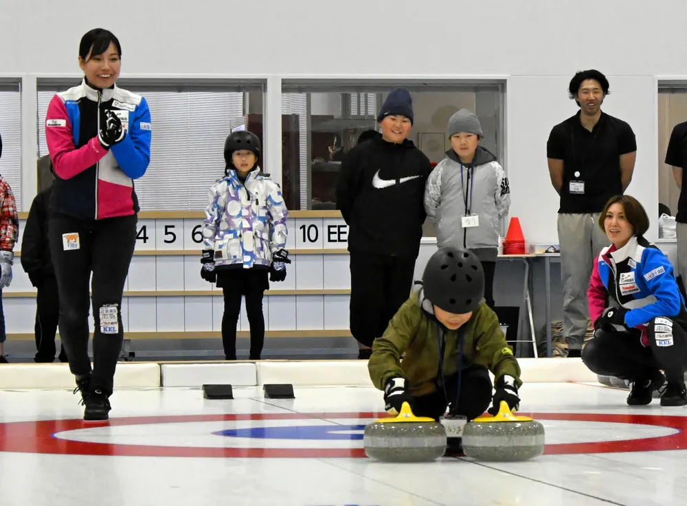 子どもたちにカーリングを教える近江谷杏菜選手（左端）と吉村紗也香さん（右端)
