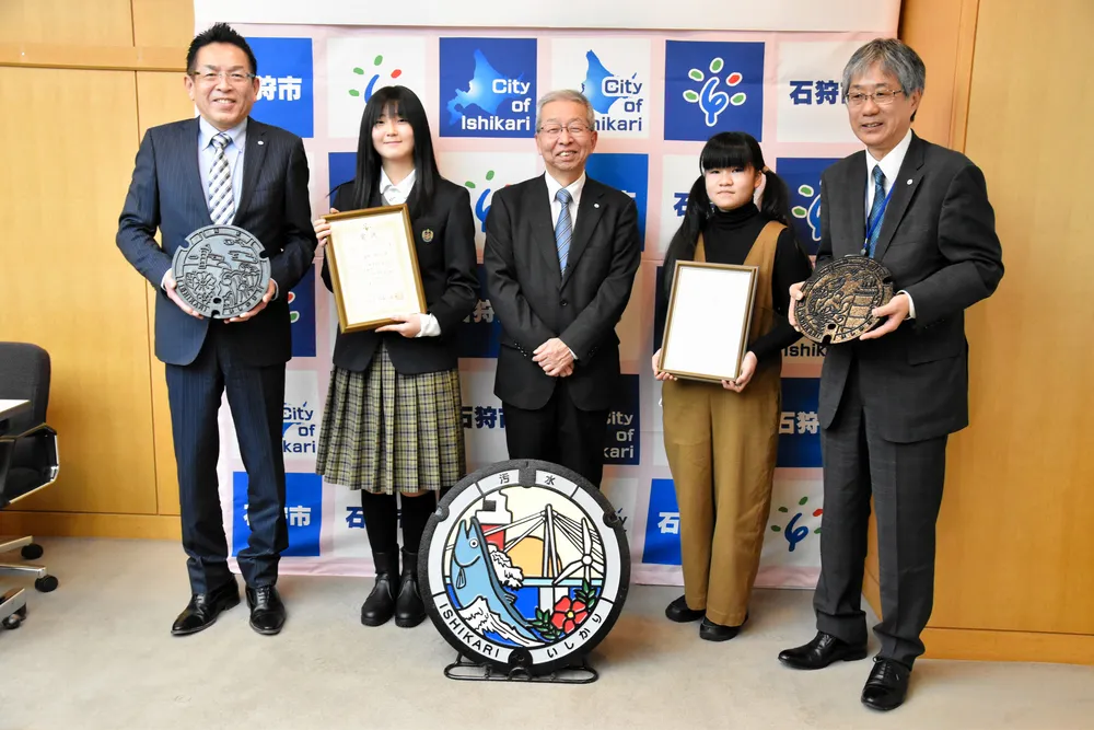 マンホールのデザインに選ばれた漆原さん（左から２人目）と公共雨水桝のデザインに選ばれた高橋さん（同４人目）