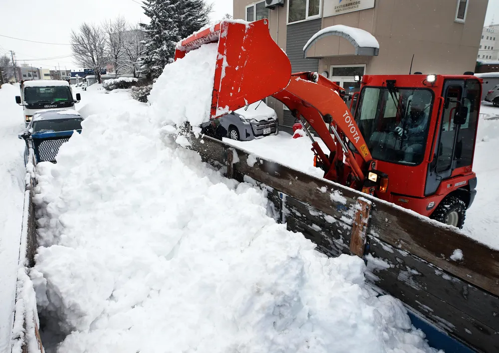 積もった雪の排雪作業に追われる市民=北見市北3西6（茂忠信撮影）