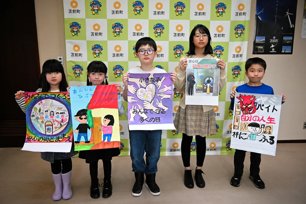 作品を手にする防犯ポスターコンクールの入賞者