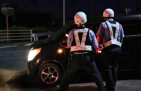 住民に避難を呼びかける警察官=18日午後8時10分、大分県中津市