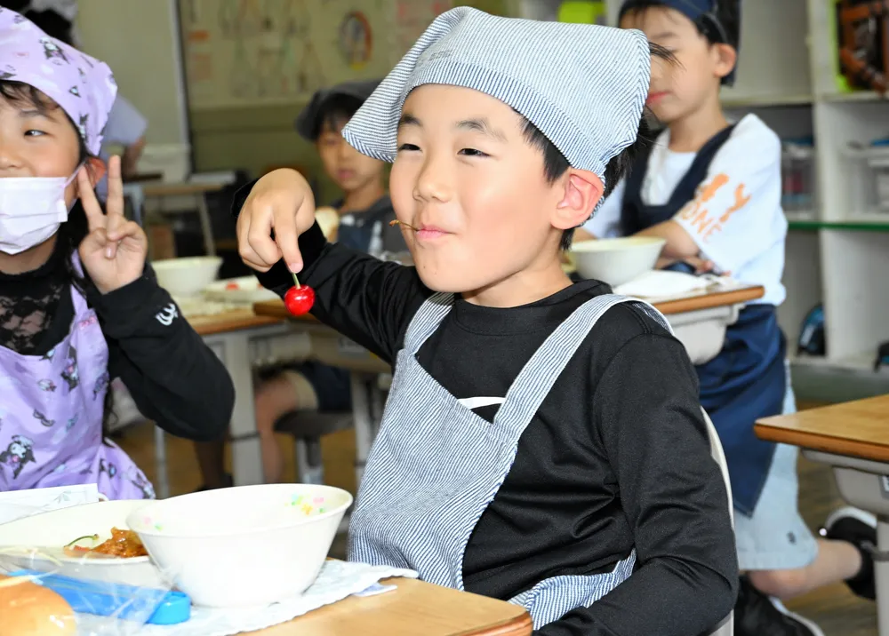 給食で振る舞われたサクランボをほおばる仁木小の1年生