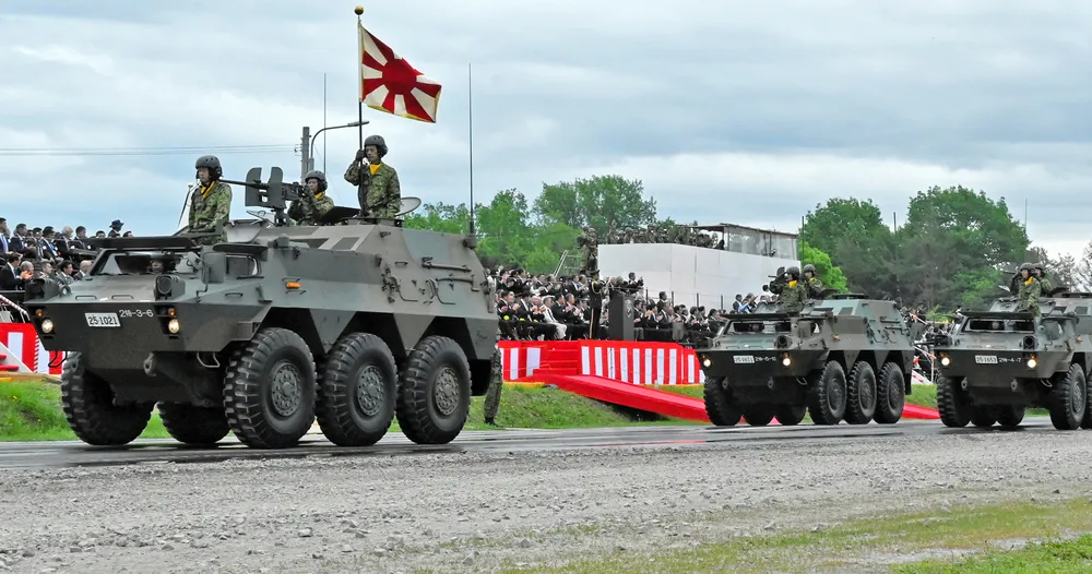 来場者が見守る中、観閲行進を行う第2師団の車両