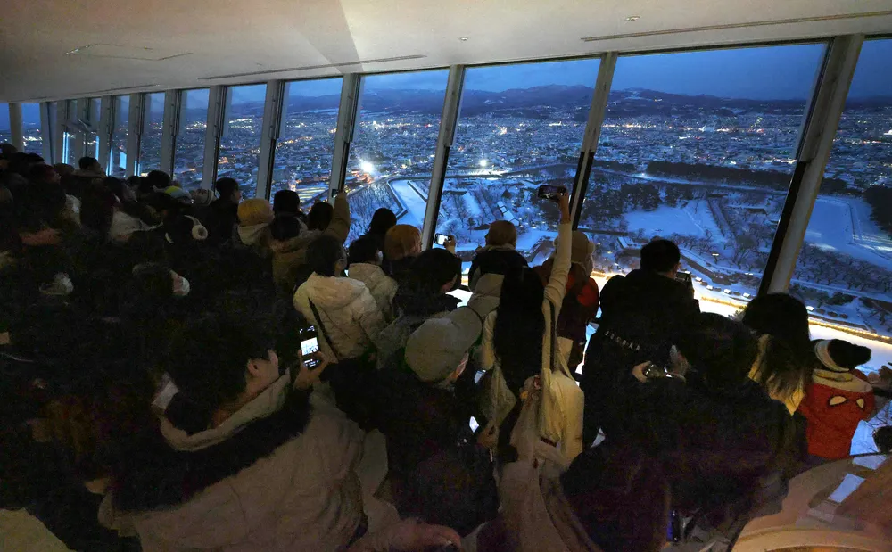 観光客で混雑する五稜郭タワーの展望台=11日午後5時30分（中本翔撮影）
