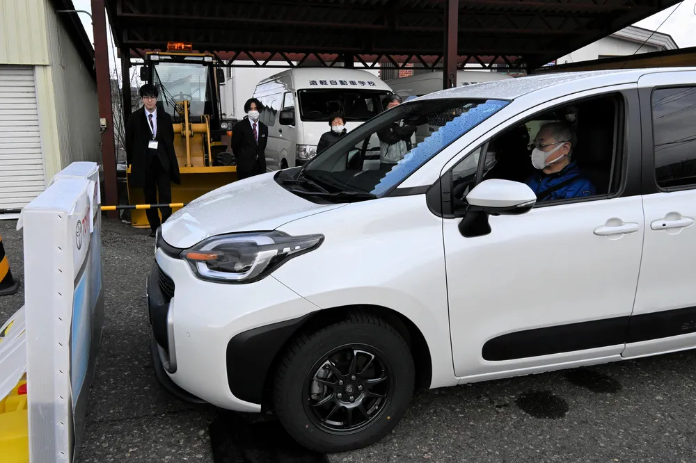 サポートカーに乗り、自動ブレーキ機能を確認する高齢者