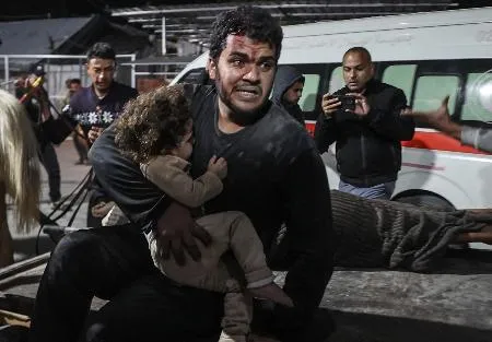 負傷した子どもを病院へ運ぶパレスチナ人=18日、ガザ地区（ゲッティ=共同）