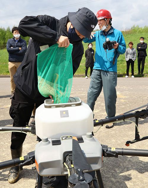 ドローンのタンクへ積み込まれる「ななつぼし」の種もみ＝５月９日、新十津川町