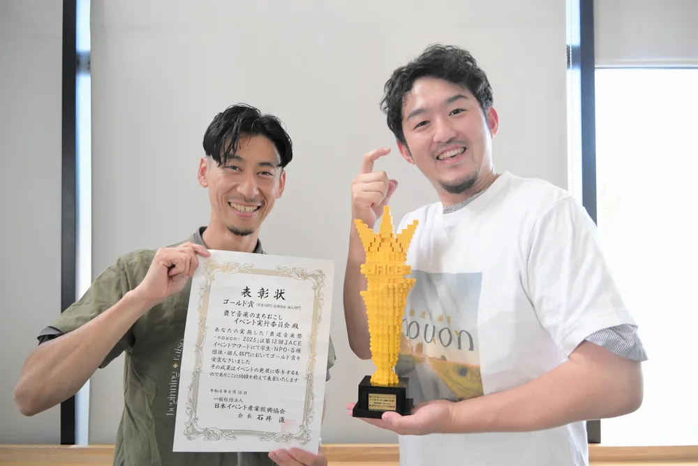 賞状とトロフィーを手に受賞を喜ぶ実行委員長の浅山彰彦さん（右）と副実行委員長の野中翔太さん
