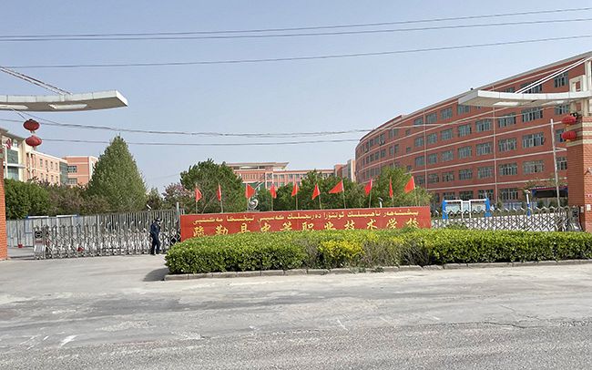 新疆ウイグル自治区カシュガル近郊で強制収容が疑われる施設の一つ。看板には職業技術学校と記されていた＝２１年４月