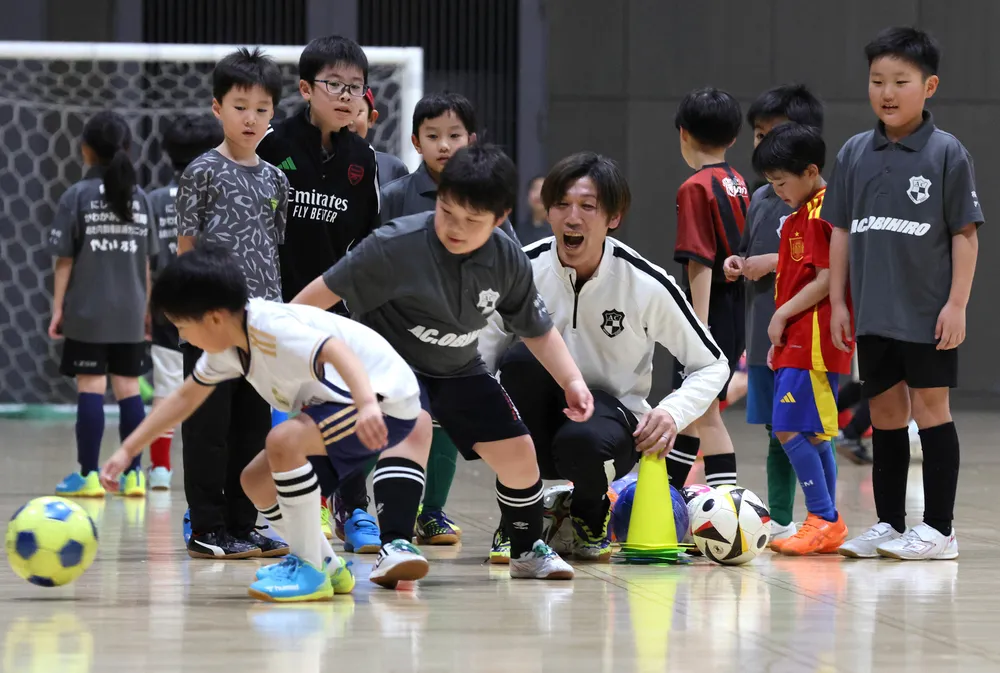 サッカースクールの小学生を指導する松島仁さん（中央）=金本綾子撮影