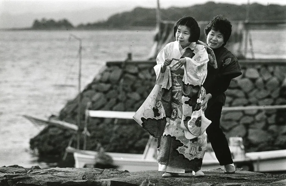 1956年に水俣病が公式に確認されるきっかけとなった1人、田中実子さん。当時32歳。和服姿で波止場を歩く妹を姉が支えた＝86年2月