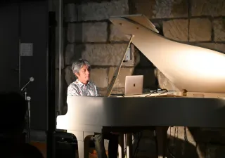 ピアノを弾きながら自然の音を織り交ぜた曲を披露する守時タツミさん