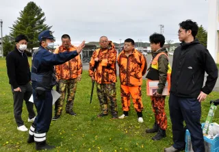 浦幌中グラウンドにヒグマが出没したとの想定で訓練に臨むハンターや警察官ら