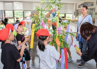 ササを飾り付けるさわら小児童と森町さわら商工会女性部のメンバーら