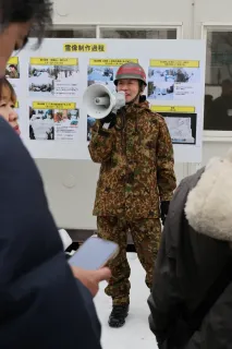 大雪像製作の苦労話などについて説明する自衛官（浜本道夫撮影）