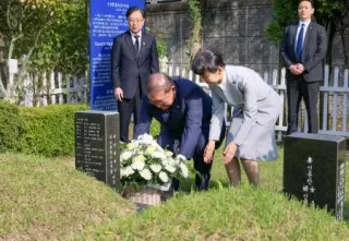 JR新大久保駅転落事故で亡くなった韓国人留学生の李秀賢さんの墓地を参拝し、献花する石破首相。右は妻の佳子さん=30日、韓国・釜山（内閣広報室提供・共同）