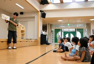 寄贈された絵本「ぐりとぐら」の読み聞かせを熱心に聞く園児たち