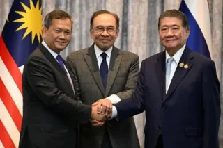 握手するタイのプムタム首相代行（右）、カンボジアのフン・マネット首相（左）と、仲介したマレーシアのアンワル首相=28日、クアラルンプール近郊（ロイター=共同）