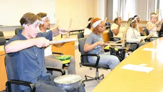バケツで作った太鼓の演奏を披露する米国の高校生たち