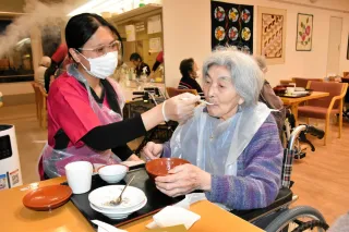 北見市内の介護老人保健施設「いきいき」で入居者に食事支援をするインドネシア人女性（左）