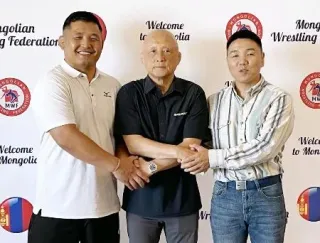 レスリングのモンゴル代表総監督就任が決まり、関係者と握手する栄和人氏（中央）=23日、ウランバートル（本人提供）