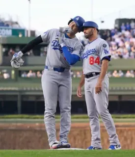 カブス戦の3回、右前打を放ち、一塁コーチ（右）とヘルメットを合わせるドジャース・大谷=シカゴ（共同）