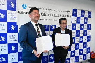協定締結書を手にする尾田洋平共同代表（左）と山内浩彰斜里町長