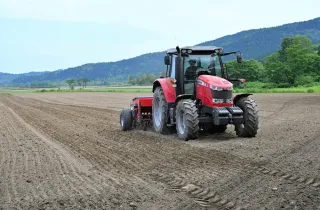 トラクターによる種まきが進むソバ畑