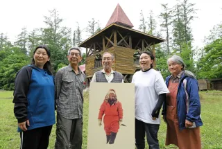 活動拠点のログハウスの前で40年の歩みを振り返る「植村直己・帯広野外学校」の会員たち（小川泰弘撮影）